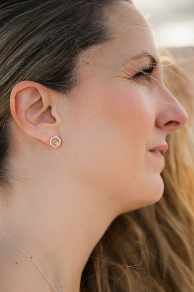 Woman wearing silver and gemstone hexagon stud earring