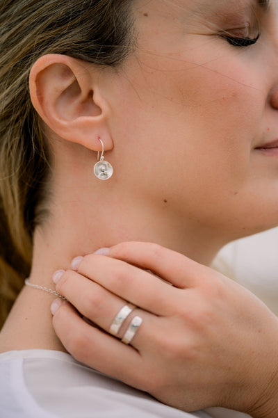 woman wearing handmade silver earrings and ring